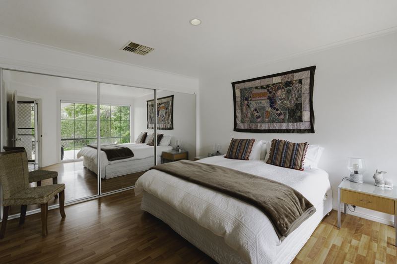 A queen bedroom with mirrored robes